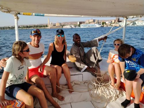a group of people sitting on the back of a boat at Nile View Guest House in Aswan