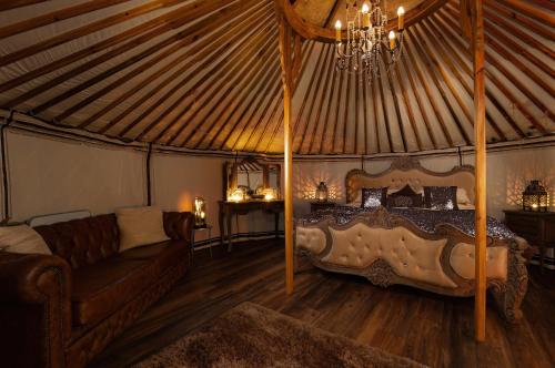 a bedroom with a bed and a couch in a yurt at Lincoln Yurts in Lincoln