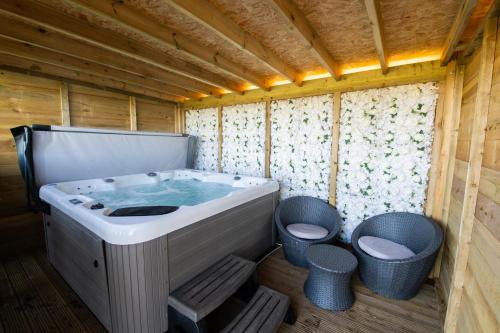 Lincoln Yurts في لينكولن: حوض استحمام في غرفة خشبية مع علبتين قمامة
