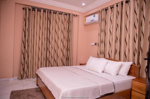 una camera con letto e finestra con tende di Impeccable 1-Bedroom Furnished Apartment in Accra a Accra