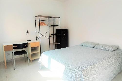 1 dormitorio con cama, escritorio y escritorio en Beautiful private and exterior double room. en Esplugues de Llobregat
