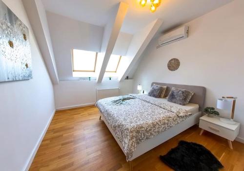 a white bedroom with a bed in a attic at Old Town Beautiful Mansard in Bucharest