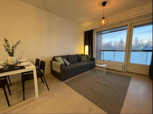 een woonkamer met een bank en een tafel bij Kaksio keskustassa ja rannan läheisyydessä in Hämeenlinna