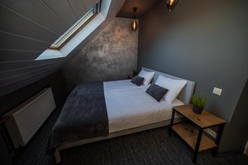 a small bedroom with a bed and a skylight at Kalniem Pāri Guest House 