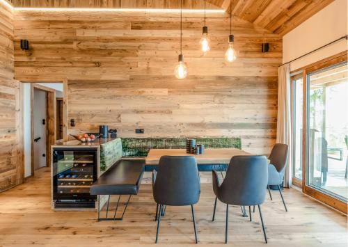 a dining room with wooden walls and a table and chairs at Brandlalm Chalets in Gundisch