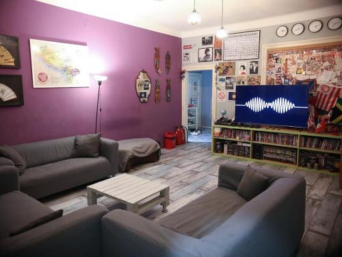 a living room with two couches and a tv at Habitat Hostel in Belgrade