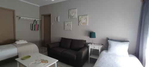 Sala de estar con sofá, cama y mesa en Kortteer vihreä huone en Rauma