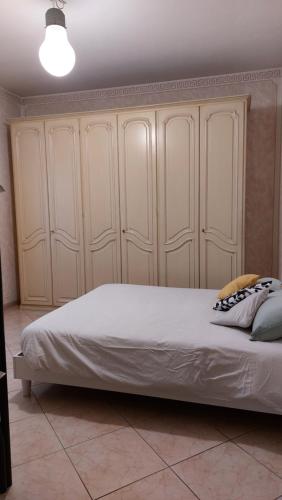 een slaapkamer met een groot bed en witte kasten bij CASA MORETTA in Alba