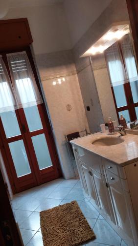 een badkamer met een wastafel en een grote spiegel bij CASA MORETTA in Alba