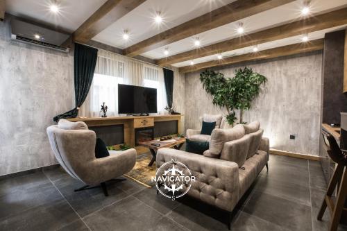 a living room with two chairs and a television at Navigator Apartment in Bijeljina