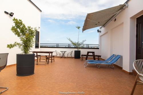 a balcony with tables and chairs and a blue chair at Stunning 2-Bedroom Furnished Apartment in Accra in Accra
