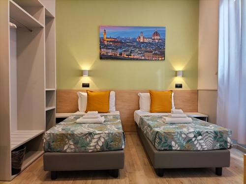 Habitación con 2 camas y una pintura en la pared. en Hotel Camilla Guelfa, en Florencia