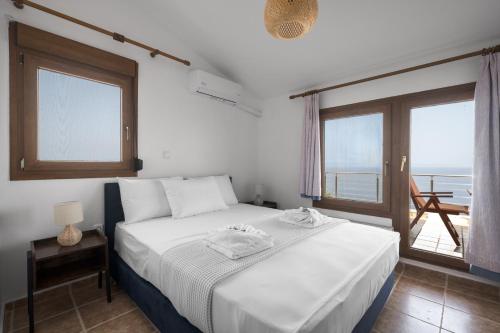 a bedroom with a bed with a view of the ocean at Afytos Wonder View by Luxlikehome in Afitos