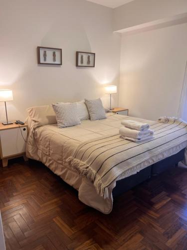 1 dormitorio con 1 cama grande y 2 lámparas. en Luminoso departamento con vista! en Córdoba