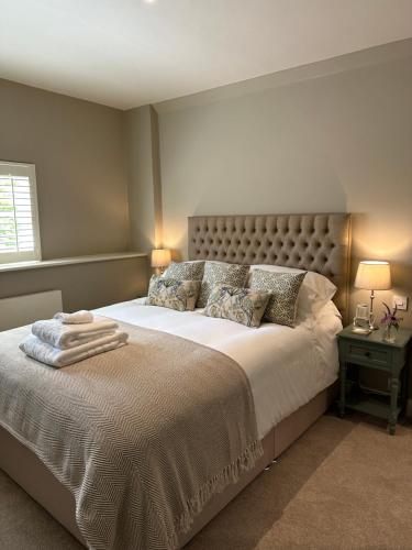a bedroom with a large white bed with two lamps at Perfectly Positioned Hambleden House in Henley on Thames