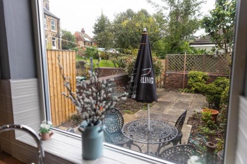 a patio with a table and an umbrella at Horbury High St Wakefield in Horbury