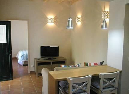 a living room with a table and a television at Casa Azenhas in Azenhas do Mar
