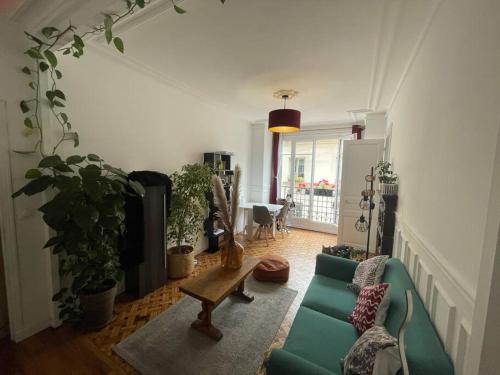 un salon avec un canapé vert et une table dans l'établissement L'authentique vie parisienne, à Paris