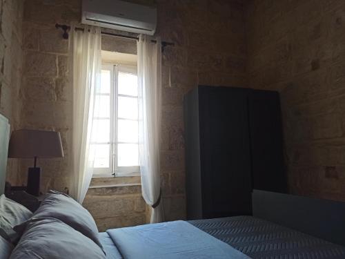 a bedroom with a bed and a window at Beautiful 1-Bed Apartment in Hal Qormi in Qormi