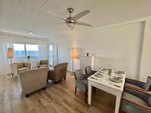 een woonkamer met een tafel en stoelen bij Seaview Beach Apartment Dasoudi in Limassol