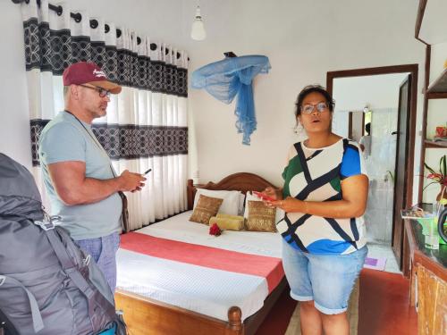um homem e uma mulher numa sala com uma cama em AnandaHomestay em Kandy