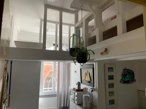 a kitchen with a loft bed with a window at Studette tiny house de l église 12 m2 in Ault