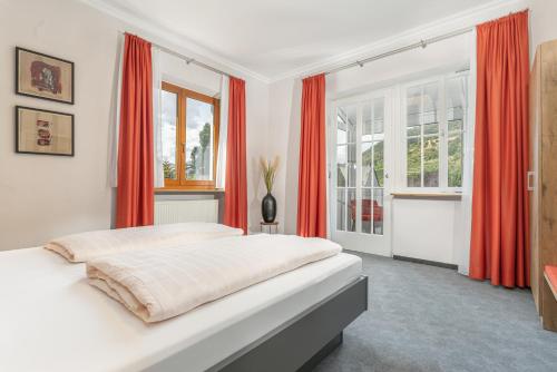 a bedroom with a large bed with red curtains at Parkhotel Cochem in Cochem