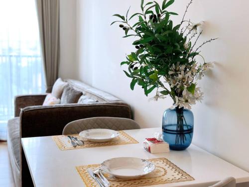 a table with a blue vase with flowers on it at Astra condo清迈市中心古城高端温馨公寓两卫浴wifi泳池健身房山景城景房 in Chiang Mai