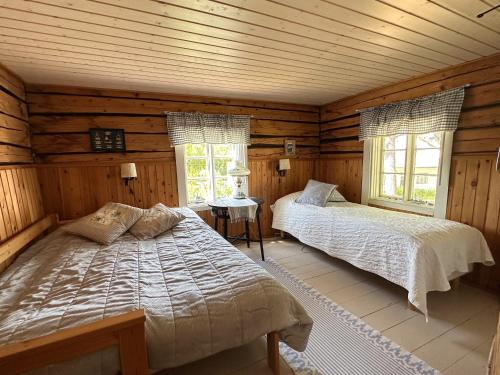 een slaapkamer met 2 bedden in een blokhut bij Lillby Bed&Breakfast 