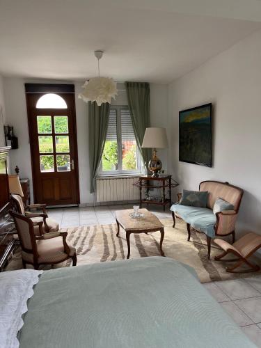 1 dormitorio con cama, sillas y mesa en Maison 90 m2 (Logement complet), en Miraumont