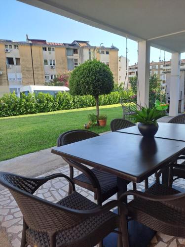 un tavolo e sedie seduti su un patio di Apartments Dali a Budua
