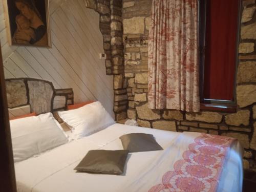 1 dormitorio con cama y pared de piedra en Cottage Milvia, en Tortoreto Lido
