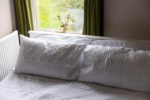 a white bed with white pillows and a window at Horbury High St Wakefield in Horbury