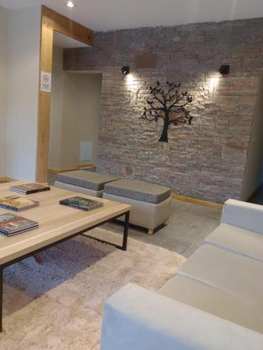 a room with two tables and a tree on the wall at Hostería Las Semillas in Villa La Angostura