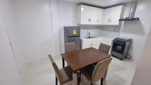 a kitchen with a table and chairs and a refrigerator at Brand New Camella 2 Bedroom House in Butuan