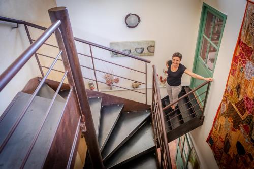 een vrouw op de trap in een huis bij Des Lits Sur La Place in Hérépian