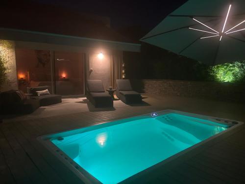 a swimming pool in a backyard at night at CHAMBRE DELUXE 3 vue mer SPA de NAGE in Ajaccio