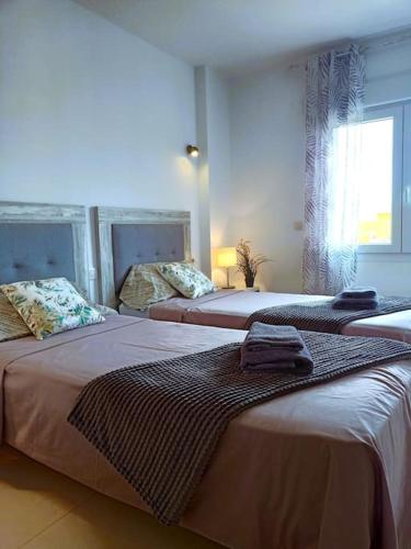 a bedroom with two beds with towels on them at Apartamento Panorama Mar in Punta Prima