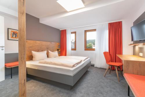 a bedroom with a bed and a desk and a chair at Parkhotel Cochem in Cochem