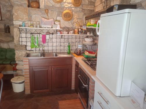 cocina con fregadero y nevera blanca en Cottage Milvia, en Tortoreto Lido