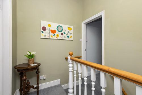 a hallway with a stairway with a painting on the wall at Horbury High St Wakefield in Horbury