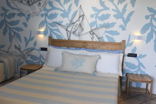 a bedroom with a bed with a pirate ship on the wall at Villa Elicriso in Carloforte