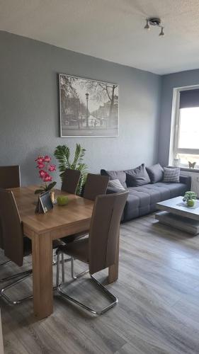 salon z drewnianym stołem i kanapą w obiekcie Flensburg Strandnah 2 w mieście Flensburg