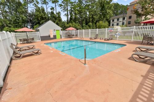 a swimming pool with chairs and a fence at Motel 6 - Newest - Ultra Sparkling Approved - Chiropractor Approved Beds - New Elevator - Robotic Massages - New 2023 Amenities - New Rooms - New Flat Screen TVs - All American Staff - Walk to Longhorn Steakhouse and Ruby Tuesday - Book Today and SAVE in Kingsland