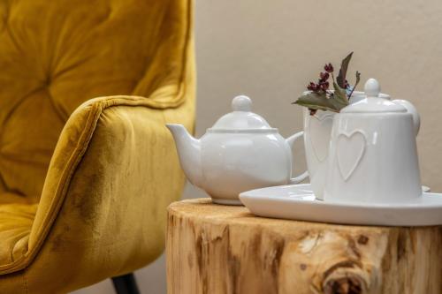 a tea pot on a table with a chair at Hotel Folgarida in Folgarida