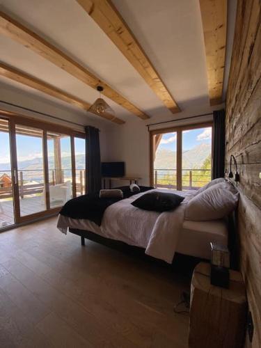 - une chambre avec un grand lit dans une pièce dotée de fenêtres dans l'établissement Les Arcs - Chalet Arc Ô Mont, à Arc 1600