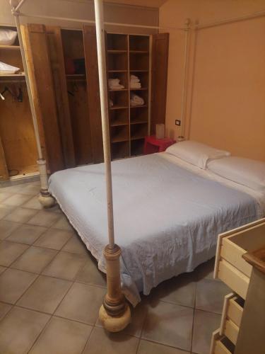 a bedroom with a bed with a white sheets and a pole at Casa campagna bosco in Frassineta
