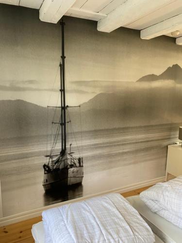 a bedroom with a painting of a boat in the water at Barkeryd Norrtorpet in Nässjö