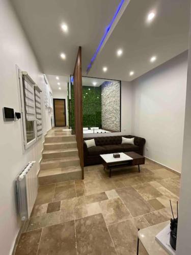 un salon avec un canapé et une table dans l'établissement Maison Hanaa, Sauna & Spa, à Pierrefitte-sur-Seine