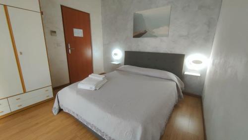 ein Schlafzimmer mit einem weißen Bett mit zwei Leuchten in der Unterkunft Hotel Eriale in Rimini